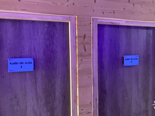 two purple doors with signs that say smile off stimuli at World Hotel in Saint-Vulbas