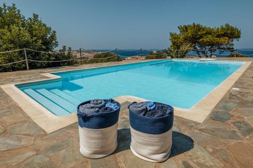 a swimming pool with two trash cans in front of it at Terra in Parikia