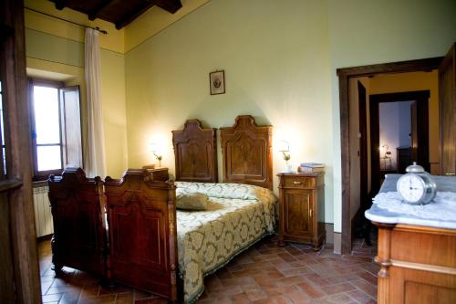 sypialnia z dużym drewnianym łóżkiem w pokoju w obiekcie VILLA LE BALZE Tuscany, private pool, property fenced, pet allowed. w mieście Poppi