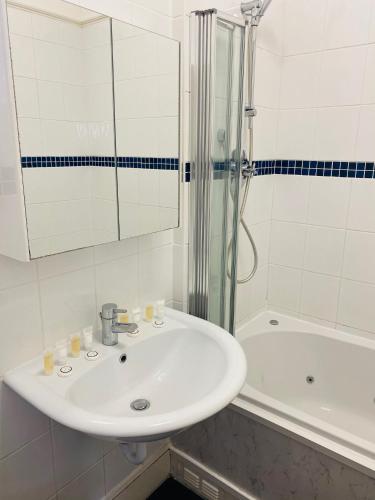 a white bathroom with a sink and a shower at The Grosvenor in Clacton-on-Sea