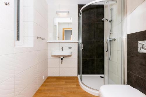een badkamer met een douche en een wastafel bij Apartamenty Villa Baltic Sun I in Międzywodzie