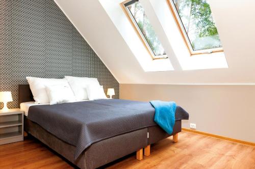 een slaapkamer met een bed en 2 dakramen bij Apartamenty Villa Baltic Sun I in Międzywodzie