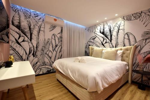 a bedroom with a bed with a mural of plants at Private pool Luxury penthouses sea view Eilat in Eilat