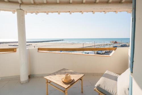 a room with a table and a view of the beach at Hôtel Casa Marina in Saintes-Maries-de-la-Mer
