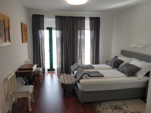 a bedroom with a bed and a desk and windows at Villa Diamond in Žrnovnica