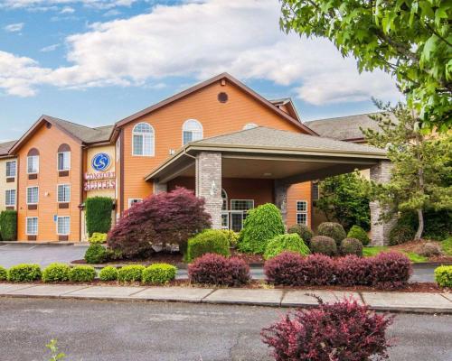 a hotel building with bushes in front of a street at Comfort Suites Corvallis in Corvallis