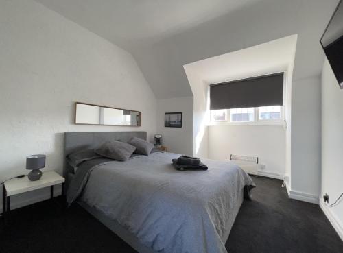 Un dormitorio con una cama grande y una ventana en One-Bedroom flat in Cheam Village en Cheam