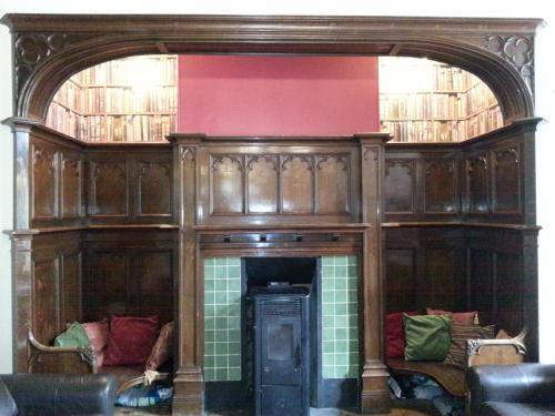 a room with a fireplace with two couches at Hargate Hall Self Catering in Buxton