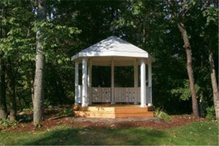 a white gazebo in the middle of a yard at Northern Lights Lodge in Stowe