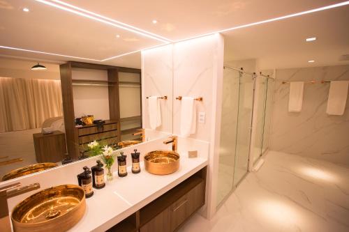 a bathroom with two sinks and a shower at Vidam Hotel Aracaju - Transamerica Collection in Aracaju