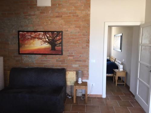 a living room with a couch and a brick wall at Agriturismo Il Capitolo in Carpaneto Piacentino