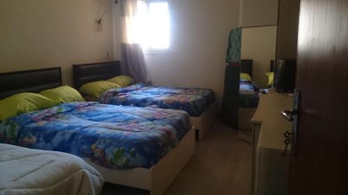 a room with three beds and a mirror at العين السخنة لاڤيستا توباز in Ain Sokhna