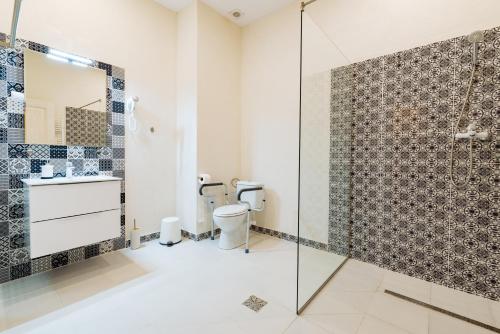 uma casa de banho com um WC e uma cabina de duche em vidro. em Pensiunea Salina Gymnasium em Turda