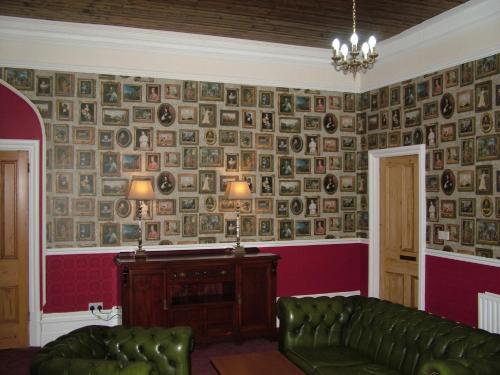 a living room with a couch and a wall of money at Hargate Hall Self Catering in Buxton