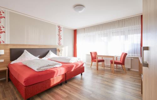 a bedroom with a bed and two chairs and a table at Landgasthof zur Sonne in Emmingen-Liptingen