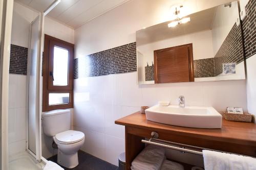 a white bathroom with a sink and a toilet at Hostau Era Claverola in Salardú