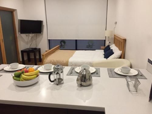 a kitchen with a table with a bowl of fruit on it at Carlingford Marina Apartments in Carlingford