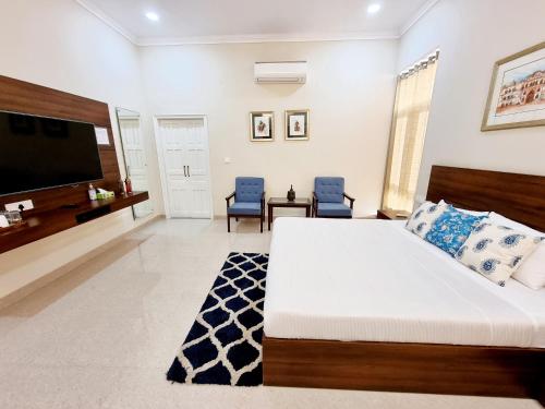 a bedroom with a large bed and a flat screen tv at The Heritage Villa in Patiāla
