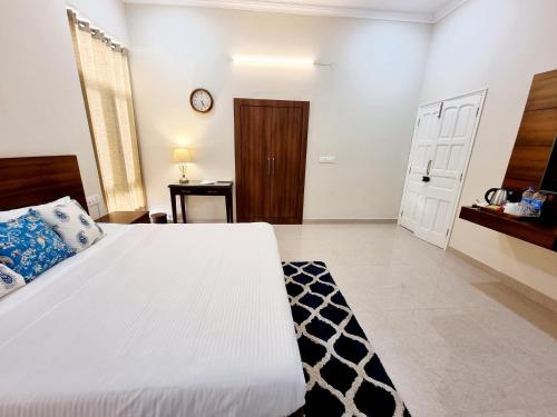 a bedroom with a large white bed and a door at The Heritage Villa in Patiāla