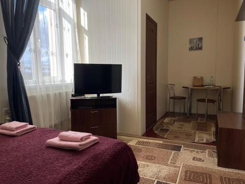 - une chambre avec une télévision et un lit avec 2 serviettes dans l'établissement Motel Tranzyt Plus, à Girka Polonka