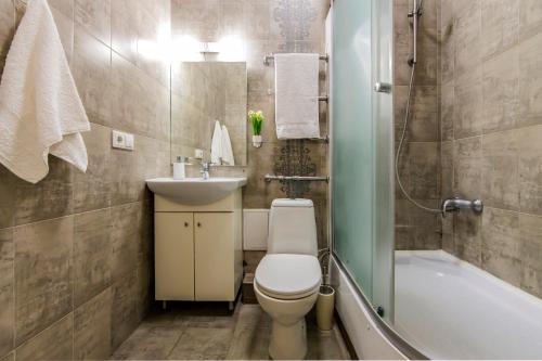 La salle de bains est pourvue de toilettes, d'un lavabo et d'une baignoire. dans l'établissement 2к квартира навпроти ТРЦ Гуллівер, à Kiev