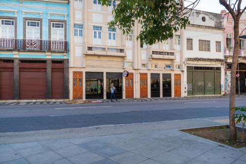 a person walking down a street in front of a building at Pompeu Rio Hotel in Rio de Janeiro