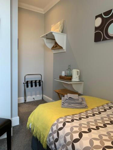 a bedroom with a bed with a yellow blanket at Armada Guesthouse in Redcar