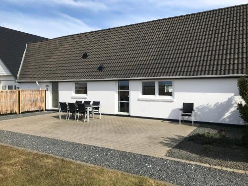 a patio with chairs and a white house at Havrevang, Luksus ferielejligheder in Lønstrup
