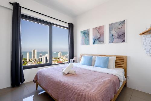 una camera da letto con un letto con una grande finestra di De Pastel Studio - SeaView at 218 Tropicana NEAR Komtar Food Heaven with Netflix & TV Box a George Town