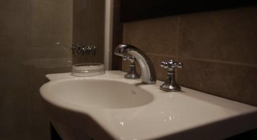 Departamentos Premium - 2 Ambientes - Excelente ubicación في ميرامار: بالوعة بيضاء في الحمام مع مرآة