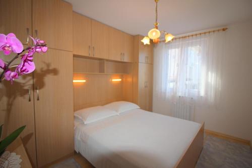 ein Schlafzimmer mit einem weißen Bett und einem Fenster in der Unterkunft Apartment Leticija near city center in Poreč