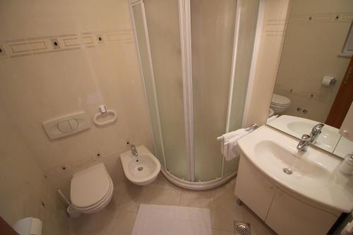 ein Bad mit einer Dusche, einem WC und einem Waschbecken in der Unterkunft Apartment Leticija near city center in Poreč