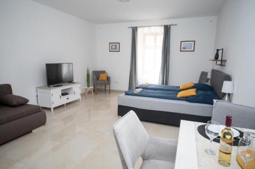 a bedroom with a bed and a living room at Kossuth Apartmanház in Tata