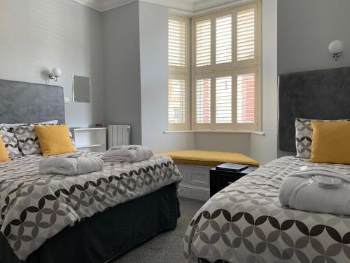 a bedroom with two beds and a window at Armada Guesthouse in Redcar