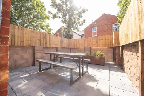 a picnic table in a backyard with a wooden fence at Franklin Lodge in Reading