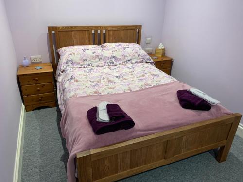 a bed in a bedroom with two dressers and a bedspread at Sea Shells in Greatstone