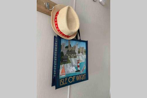 a hat hanging on a wall with a sign on it at Bliss Beach Lodge Breath taking views in Bembridge