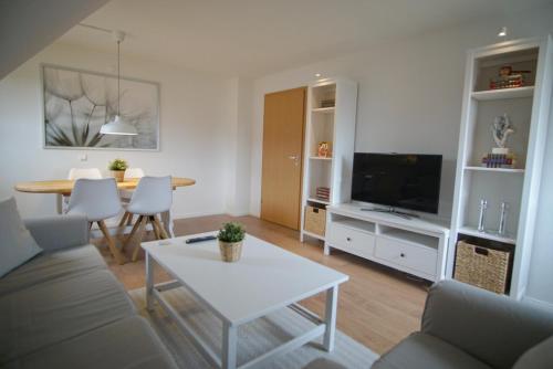 a living room with a couch and a table at Ferienwohnung HeideZeit Soltau - Neu mit Spielturm in Soltau