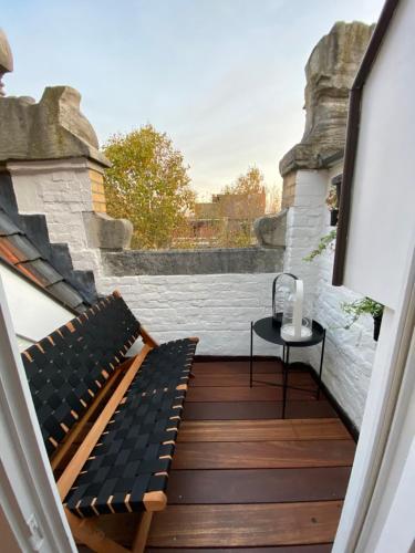 a small balcony with a bench and a table at B&B Achilles in Ghent