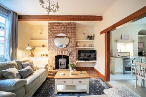 a living room with a couch and a fireplace at The Cottage in Chester, Sleeps 6 with FREE Parking in Chester