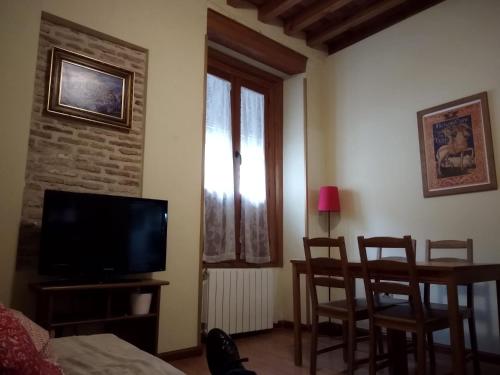 a living room with a tv and a table and chairs at Casa de Gaitán in Toledo