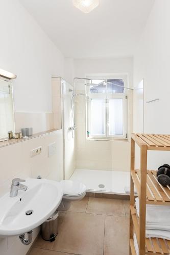 a white bathroom with a toilet and a sink at M9 Appartment in Garmisch-Partenkirchen