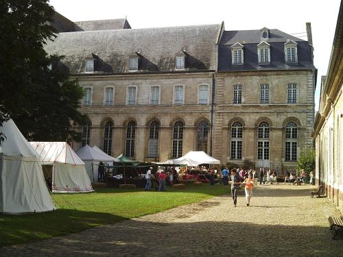 a group of people walking in front of a large building at La Bergerie du festel in Saint-Riquier