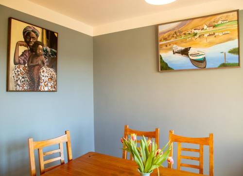 a dining room with a table and two pictures on the wall at Dingle Town Holiday Home by Trident Holiday Homes in Dingle