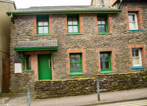 a large brick building with green doors and windows at Dingle Town Holiday Home by Trident Holiday Homes in Dingle