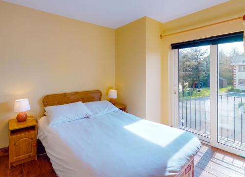 een slaapkamer met een bed en een groot raam bij Seacliff HH No 8 in Dunmore East