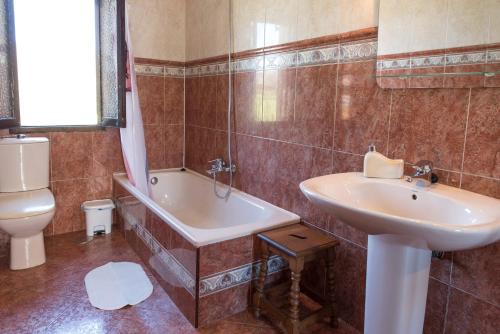 a bathroom with a sink and a tub and a toilet at Apartamentos Alegría in Santillana del Mar