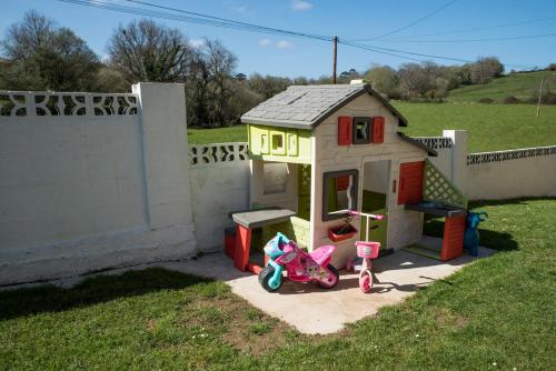 a small play house with a scooter in a yard at Apartamentos Alegría in Santillana del Mar