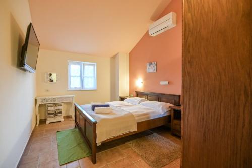a bedroom with a bed and a television in it at Villa Plasa Krk in Kras