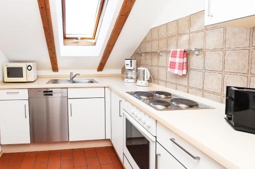 a kitchen with white cabinets and a stove top oven at M9 Appartment in Garmisch-Partenkirchen